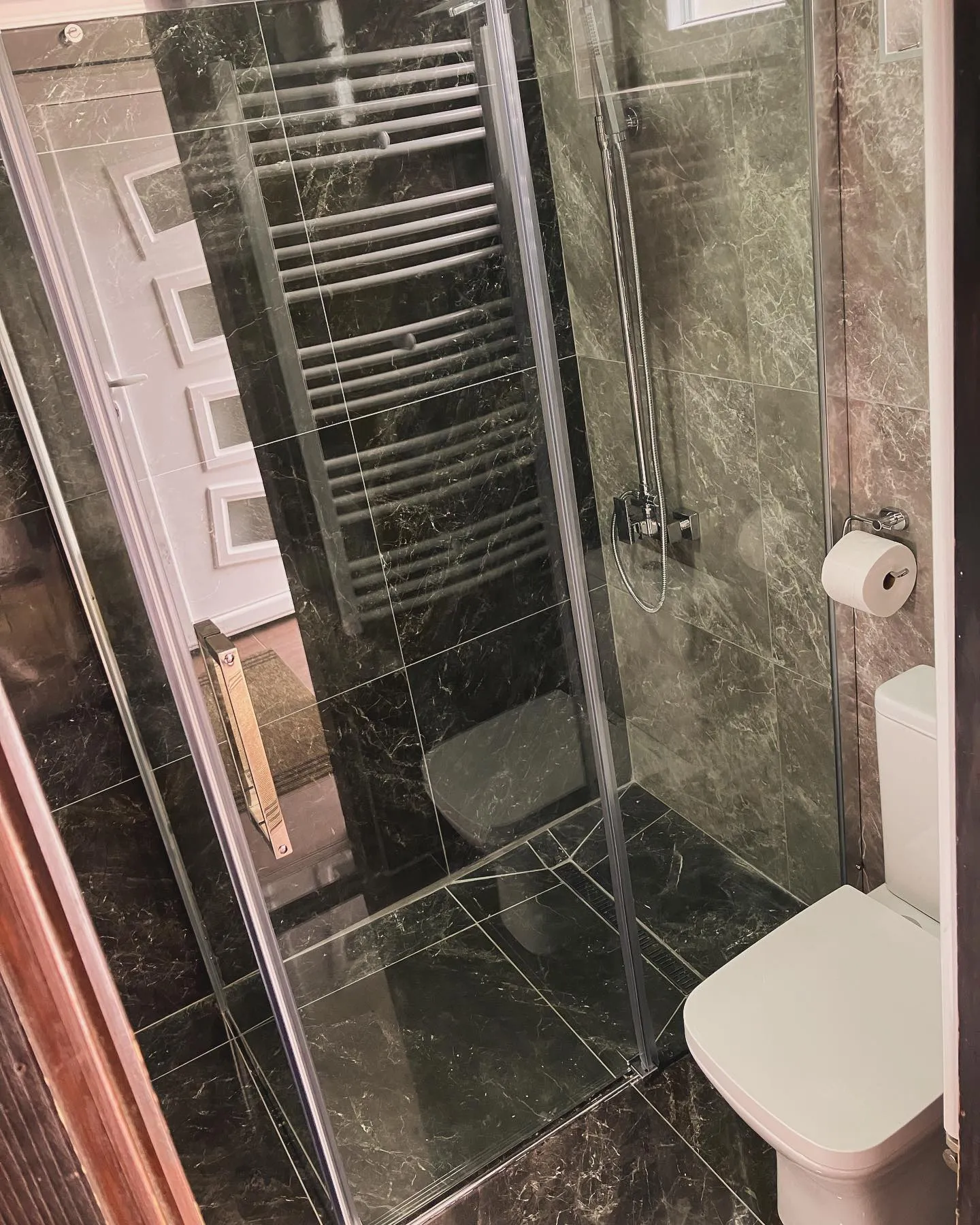 Tuš kabina sa staklenim vratima i WC šoljom — završena montaža