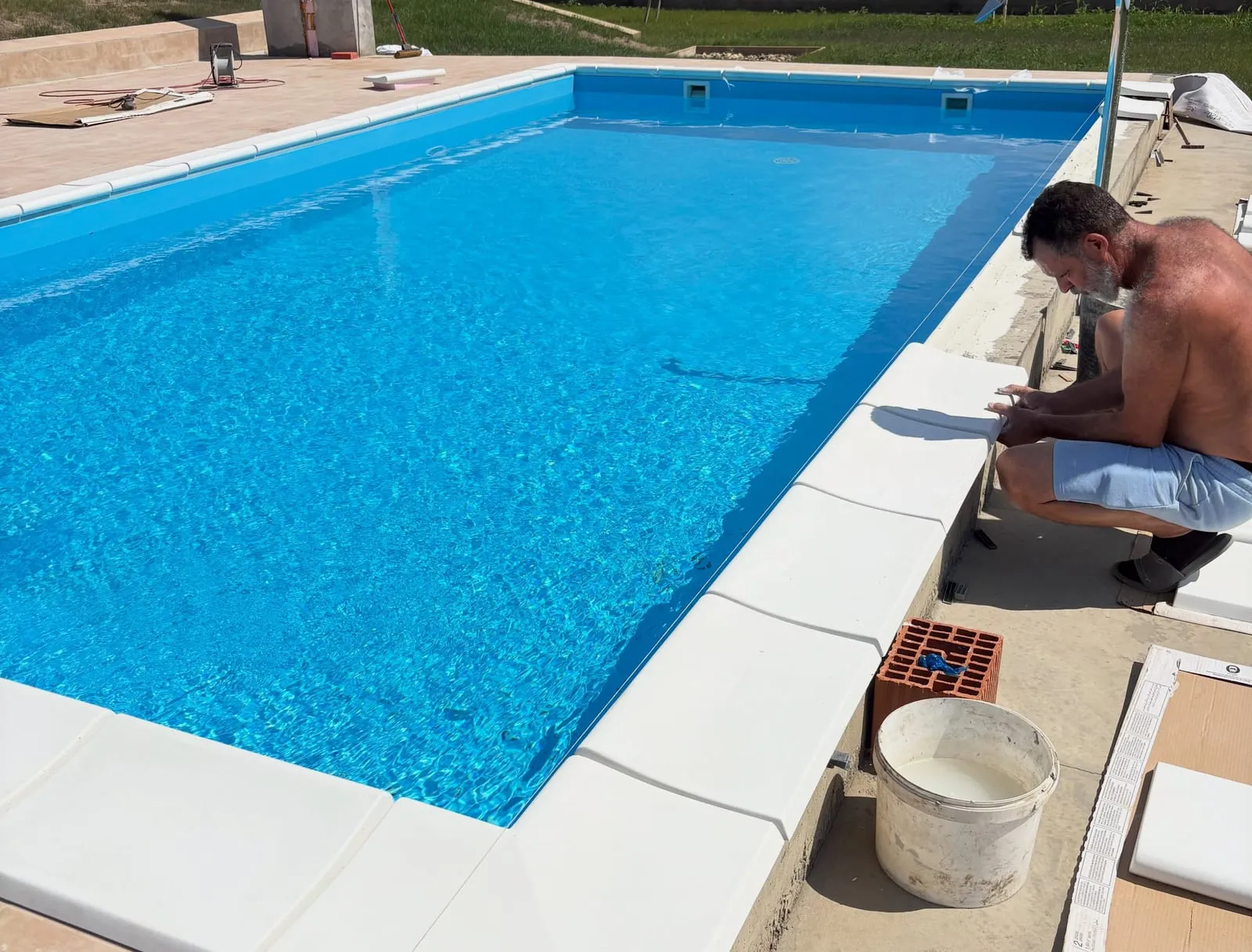 Montaža ivičnih ploča oko bazena — završni radovi